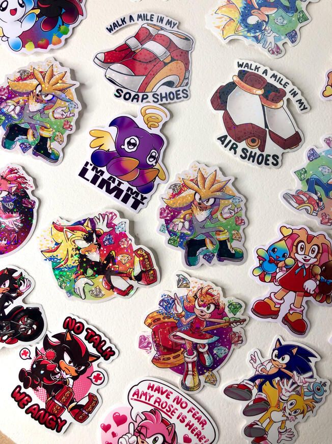 Sonic Stickers Assorted Image of various sonic stickers set out on a table. Characters include Sonic, Shadow, Amy, Cream, Silver, Blaze, Tails, and Chaos