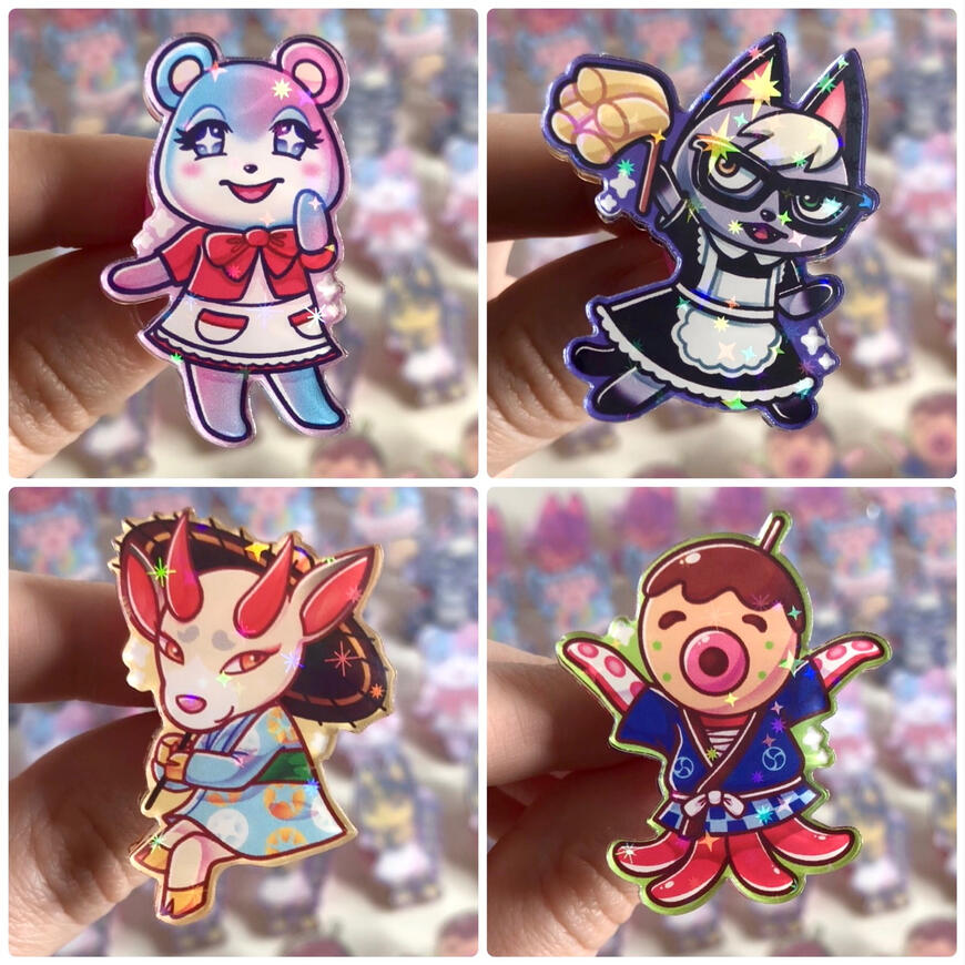 Pins2 Image of acrylic pins of villager characters from the game Animal Crossing. From left to right, top to bottom it's Judy, Raymond, Shino, and Zucker. They are holographic and have stars and sparkles on them